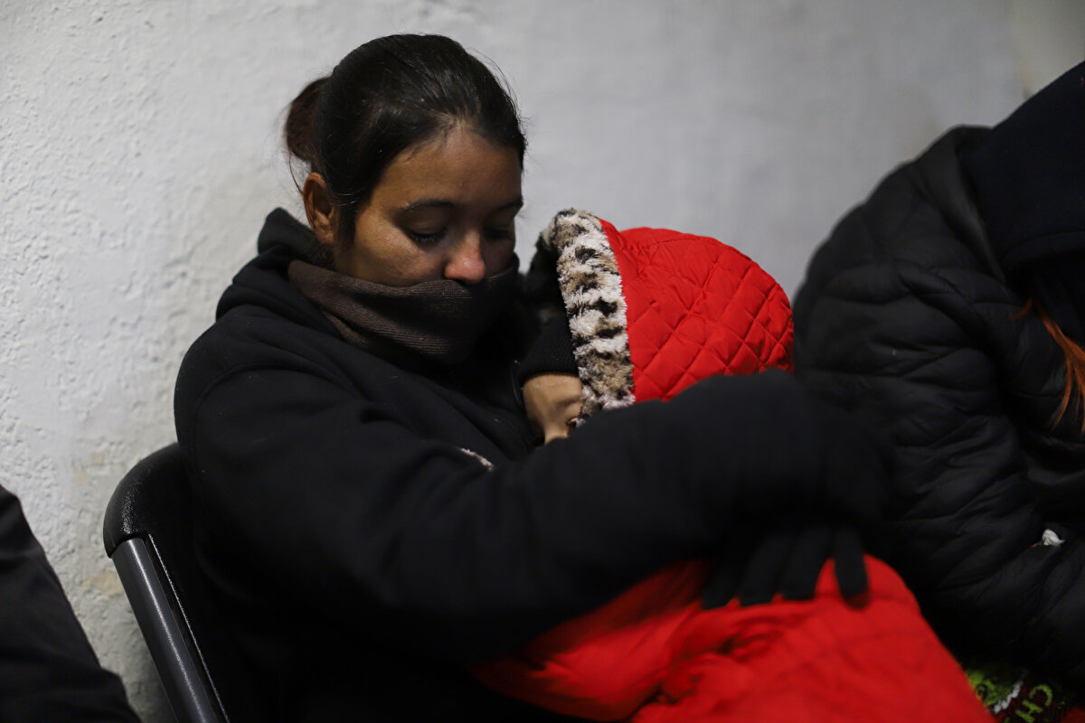 Çoğu Orta ve Güney Amerika ülkelerinden gelen düzinelerce göçmen, eldiven, şapka, ceket, kazak, panço ve kendilerini kötü hava koşullarından koruyabilecek diğer giysilerle örtülü bir şekilde oturmaya devam ediyor.