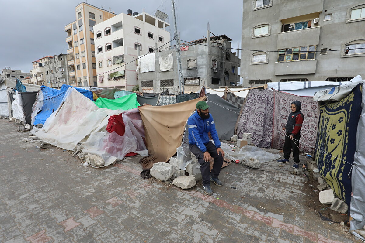 Gazze Şeridi'nin orta kesiminde yer alan Deyr el-Belah kentindeki ikinci kış mevsimini sığındıkları derme çatma çadırda geçiren ismini vermeyen 80 yaşındaki yaşlı kadın, geceleri, çadırlarını kuma sabitleyen ahşap direklerden birini tutarak geçirdiğini söyledi.