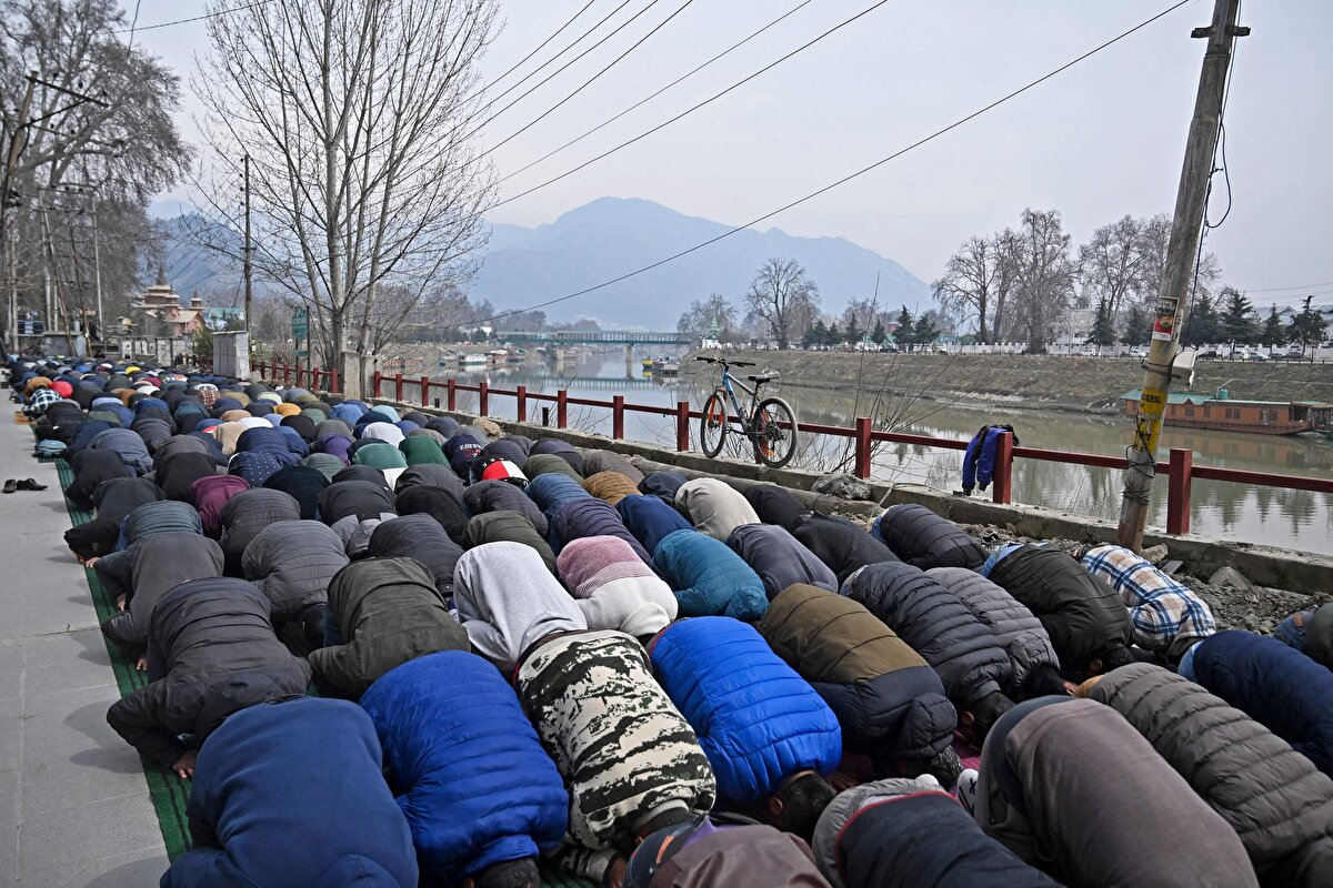 Srinagar'da caddelerde Ramazan ayının ilk cuma namazını kılan Hintli Müslümanlar.