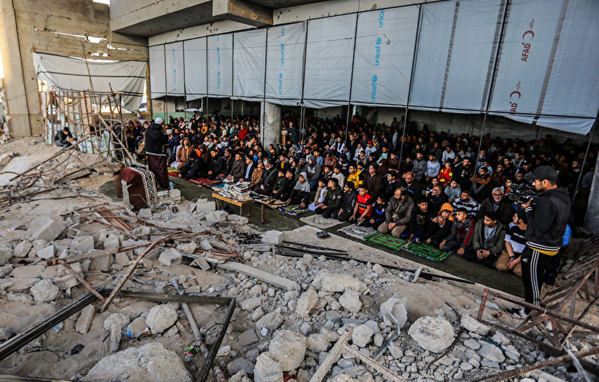 Han Yunus’un doğusunda namaz sırasında İsrail askeri araçlarından ateş açıldı<br>Güneydeki Han Yunus kentinde ise Filistinliler, doğu bölgesinden gelen sığınmacılarla birlikte bir okulda oluşturulan barınma merkezinde bayram namazını kıldı.<br><br>Görgü tanıklarından alınan bilgiye göre, Han Yunus’un doğusunda namaz sırasında ve sonrasında İsrail askeri araçlarından yoğun ateş açıldı.<br><br>Gazze Şeridi’nin orta kesiminde yer alan Nusayrat Mülteci Kampı'nda ise Filistinliler, İsrail bombardımanı sonucu tamamen yıkılan el-Kassam Camii’nin enkazı üzerinde bayram namazını kıldı. Bölgedeki birçok cami ağır hasarlı olduğu için Filistinliler, hasar gören mabetlerin avlularında namaz kılmak zorunda kaldı.<br><br>