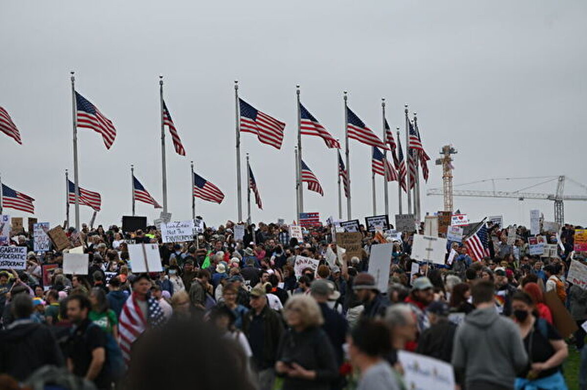 Vaşington Anıtı çevresinde toplanan kalabalık, ellerinde pankartlar ve dövizler taşıyıp, sloganlar atarak Trump yönetiminin politikalarını protesto etti.