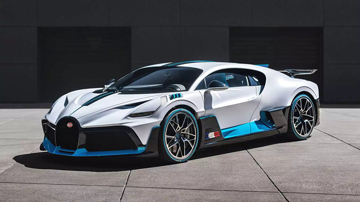 Bugatti Divo, 2018’de tanıtılan sınırlı üretim bir hiper otomobil ve adını ünlü Fransız yarış pilotu Albert Divo’dan alıyor. Bu model ikonik Chiron platformunu temel alarak tasarlanmış olup daha yüksek performans ve aerodinamik verimlilik sağlamak üzere önemli değişiklikler içeriyor. Divo’nun tasarımı, agresif hatları ve aerodinamik yapısıyla dikkat çekiyor. Yenilikçi ön ve arka kanatları, büyük bir difüzör ve sabit arka spoyler aracın yere tutunmasını artırarak virajlardaki performansını ön plana çıkarıyor. 8.0 litrelik W16 quad-turbo motoru 1500 beygir gücü üreterek aracın 0’dan 100 kms hıza 2.4 saniyede ulaşmasını sağlıyor. Bu özellikler Divo’yu düz yolda değil pistteki performansıyla öne çıkaran bir otomobil haline getiriyor.