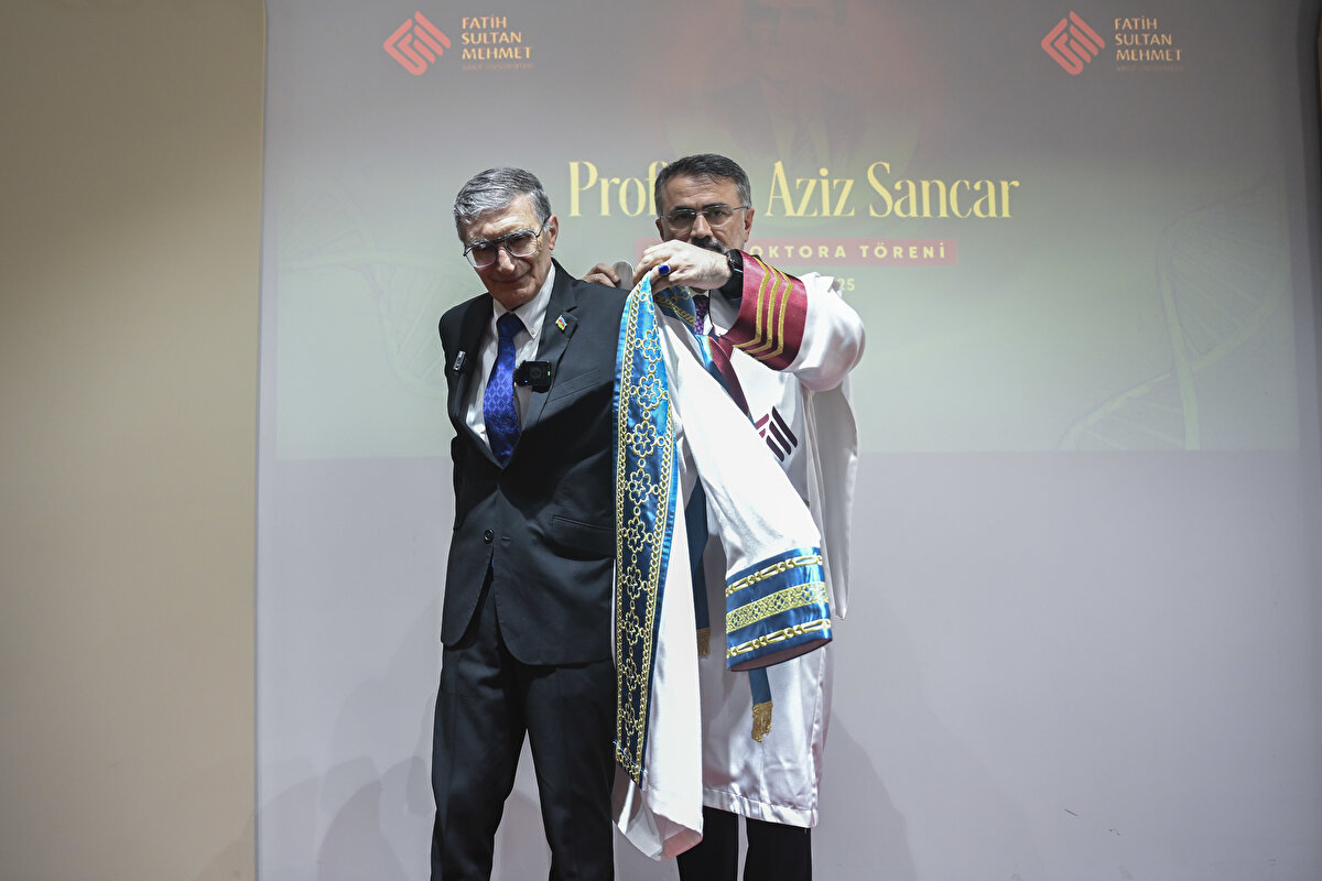 Rektör Yardımcısı Prof. Dr. Saadettin Herdem'in, üniversite senatosunun Sancar'a fahri doktora ünvanı verilmesi kararını katılımcılara okumasının ardından Rektör Şimşek, Sancar'a cüppe giydirerek fahri doktora belgesini takdim etti.