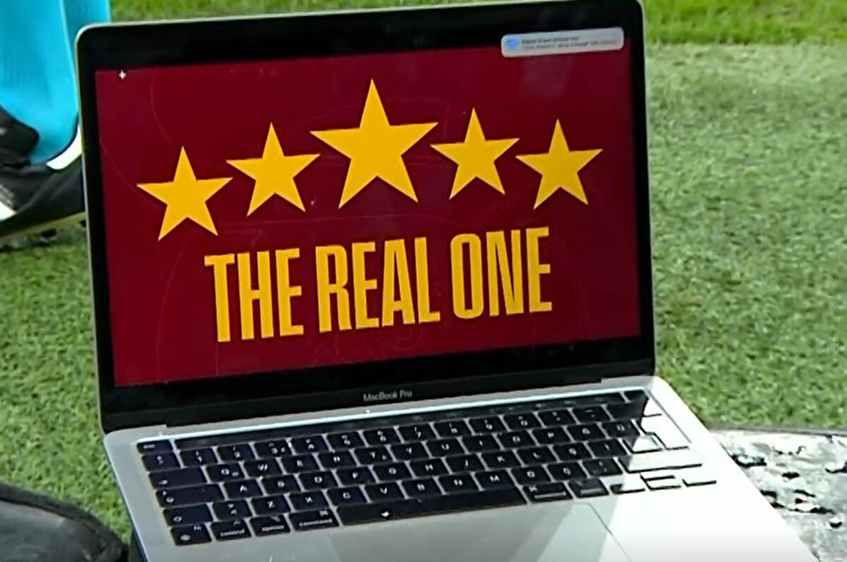 Okan Buruk, 5 yıldızlı Galatasaray logosunun olduğu laptop'u yayıncı kuruluşun kamerasının önünde koyarak Jose Mourinho ve Fenerbahçe'ye gönderme yaptı.<br>