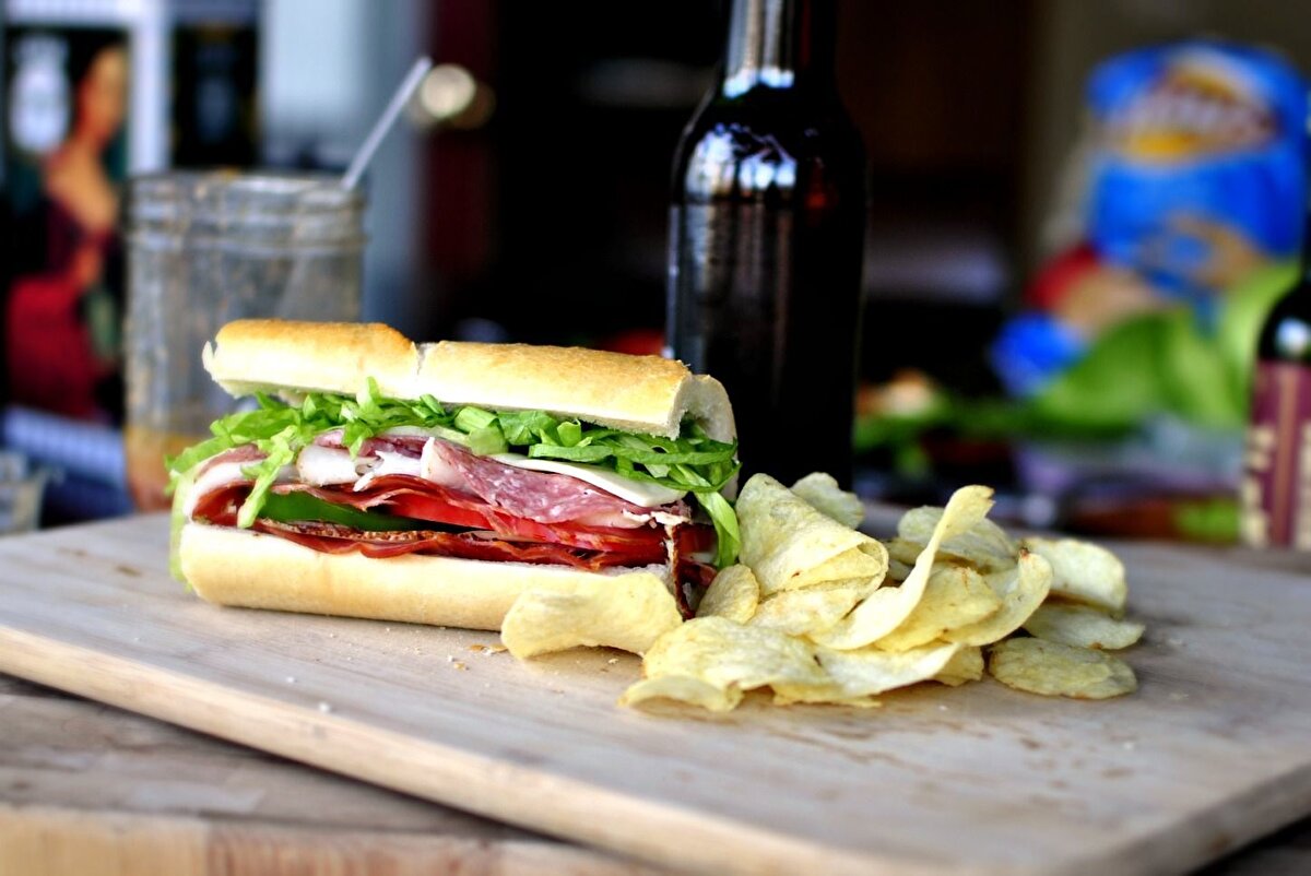 🥖 Maine’e Özgü Bir Sandviç: Italian Sandwich<br>Portland’ın mutfak mirasına geçmişten bir iz bırakmak gerekirse, o da Maine Italian Sandwich olurdu. 1902’de Amato ailesi tarafından icat edilen bu sandviç, taze pişmiş ekmek arasında jambon, peynir, domates, soğan, yeşil biber, zeytin ve salata yağı ile hazırlanıyo