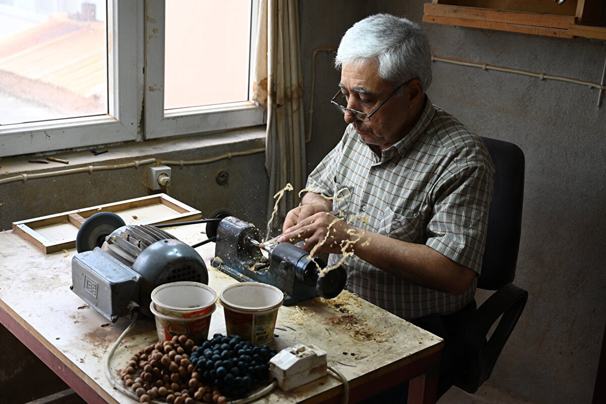 Ardından kuruttuğu kozalakların çekirdeklerini kavlatma makinesiyle kabuğundan ayıran usta, bu çekirdeklere tornavida ile şekil veriyor.