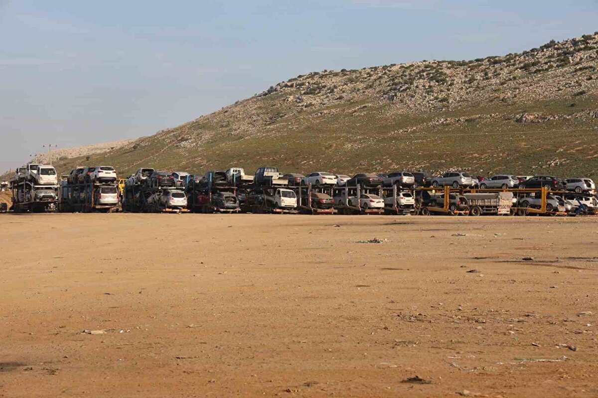 "Buradan ayda ortalama bin 500 araba karşı tarafa gidiyor"<br><br>Ayda ortalama bin 500 aracın Suriye’ye gittiğini ifade eden tır şoförü Abdulali Ay, "Ben 22 yıldır tır şoförlüğü yapıyorum. Genellikle tırlarla araç taşıyoruz. Önceden inşaat, tente ve gıda malzemeleri taşıyordum. Ayda 4 sefer yapıyoruz. Ayda ortalama bin 500 araba karşı tarafa gidiyor. Geçmiş yıllara göre yoğunluk ağırlaşmış ve artmış. Burada normalde günde bir sefer yapmamız gerekiyorken buraya gelip 5 gün bekliyoruz. Buradan da ortalama 350 ila 400 arasında tır gidiyor" ifadelerini kullandı.