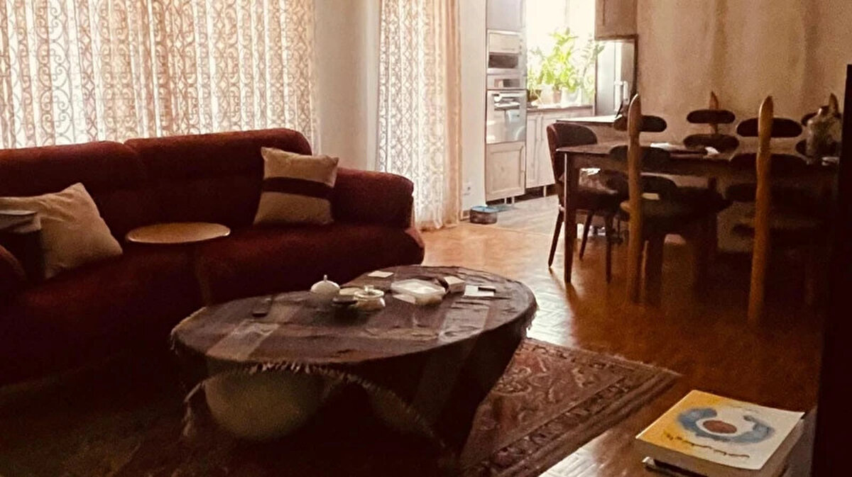 Bazı koltuklar bomboş duruyor. Bazılarının önüne valizler yığılmış. Saksı çiçekleri, biblolar ve yastıklar özenle dizilmiş, perdeler kapalı.