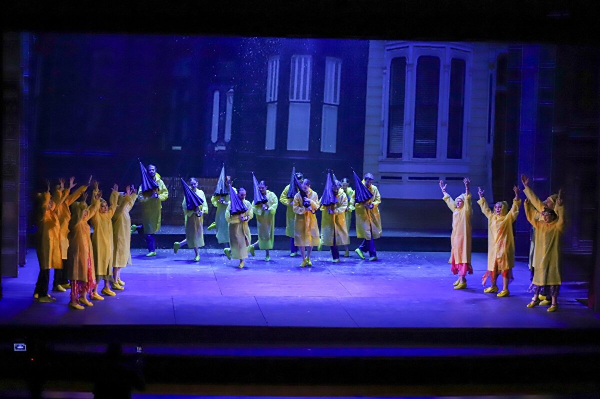 Hollywood'dan Samsun'a<br><br>“Singin’ in the Rain” müzikali ile bu büyük yolculukta yeni bir eşik daha aşılmış oldu. Yapımın rejisi ve Türkçe çevirisi Aclan Büyüktürkoğlu’na, koreografisi Yunus Emre Örgüt’e ait. Yapımın sahne estetiğini tamamlayan yaratıcı ekipte; dekor tasarımıyla Tayfun Çebi, kostüm tasarımıyla Gülnur Çağlayan Tuluk, ışık tasarımıyla Oğuz Murat Yılmaz, video projeksiyon tasarımıyla Murat Turgut ve koro düzenlemeleriyle Maria Chekriekchieva yer alıyor. Orkestranın başkemancısı olarak Didem Tepe sahnede yer alırken, müzikalin Broadway besteleri Kıvanç Tepe tarafından Samsun Devlet Opera ve Balesi Orkestrası için senfonik olarak yeniden düzenlendi.<br>Hollywood’un içi boş parıltılı dünyasının, yükselen teknolojik değişim karşısında yaşadığı dönüşümü mizahi bir dille ele alan bu yapım; yüzeysellik, kibir ve sahicilik arasındaki çatışmaları romantik bir öyküyle harmanlayarak sahneye taşıyor.