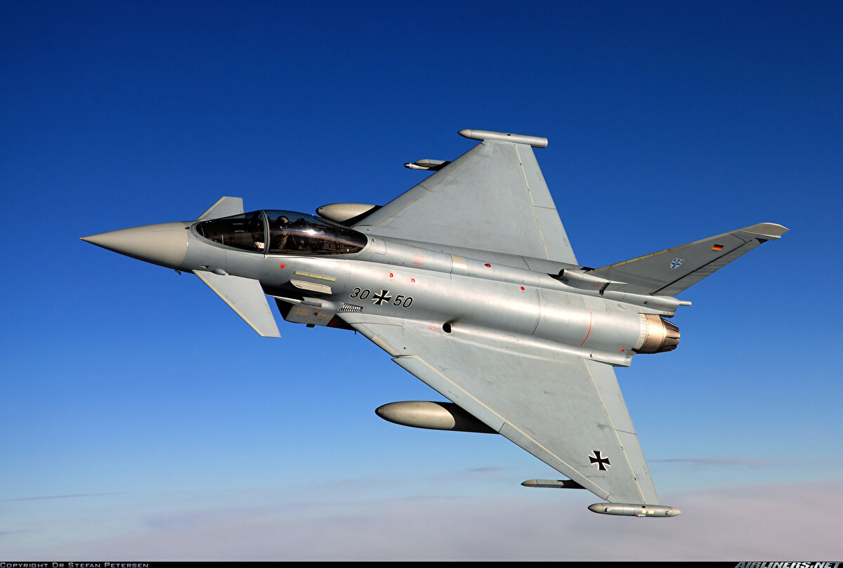 <br>Eurofighter Typhoon<br><br>Türkiye’nin ısrarla istediği, dünya çapında en önemli savaş uçaklarından biri de Eurofighter Typhoon. Bilmeyenler için Almanya, İtalya, İspanya ve Birleşik Krallık’ın ortak projesi olarak geliştirilen Eurofighter Typhoon, çok rollü dördüncü nesil bir savaş uçağı olarak modern hava kuvvetlerinin en güçlü platformlarından biri konumunda. 1980’lerde geliştirilmeye başlanan ve ilk uçuşunu 1994 yılında gerçekleştiren bu uçak, 2003 yılında aktif hizmete girdi. Eurofighter, Mach 2.0’a kadar ulaşan maksimum hızı ve gelişmiş aviyonik sistemleriyle dikkat çekiyor. Bunlar arasında Çok Fonksiyonlu Dijital Bilgi Dağıtım Sistemi (MIDS), E-SCAN radar teknolojisi ve gelişmiş baş üstü gösterge ekranı (HUD) yer alıyor.<br>