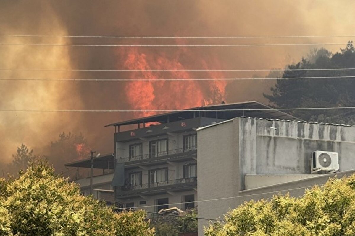 Bursa<br><br>Bursa'da tarım arazisinde çıkan yangın, evlere sıçradı.<br>Osmangazi ilçesine bağlı Demirtaş Mahallesi'nde zeytin ağaçlarının da bulunduğu makilik alanda çıkarak ormana, oradan da İsmetiye Mahallesi'ndeki evlere sıçrayan yangına havadan ve karadan iki helikopter, 14 arazöz, 36 iş ve hizmet aracı ve 137 personelle müdahale ediliyor.<br>Alevlerle mücadelede bir insansız hava aracı da kullanılıyor.