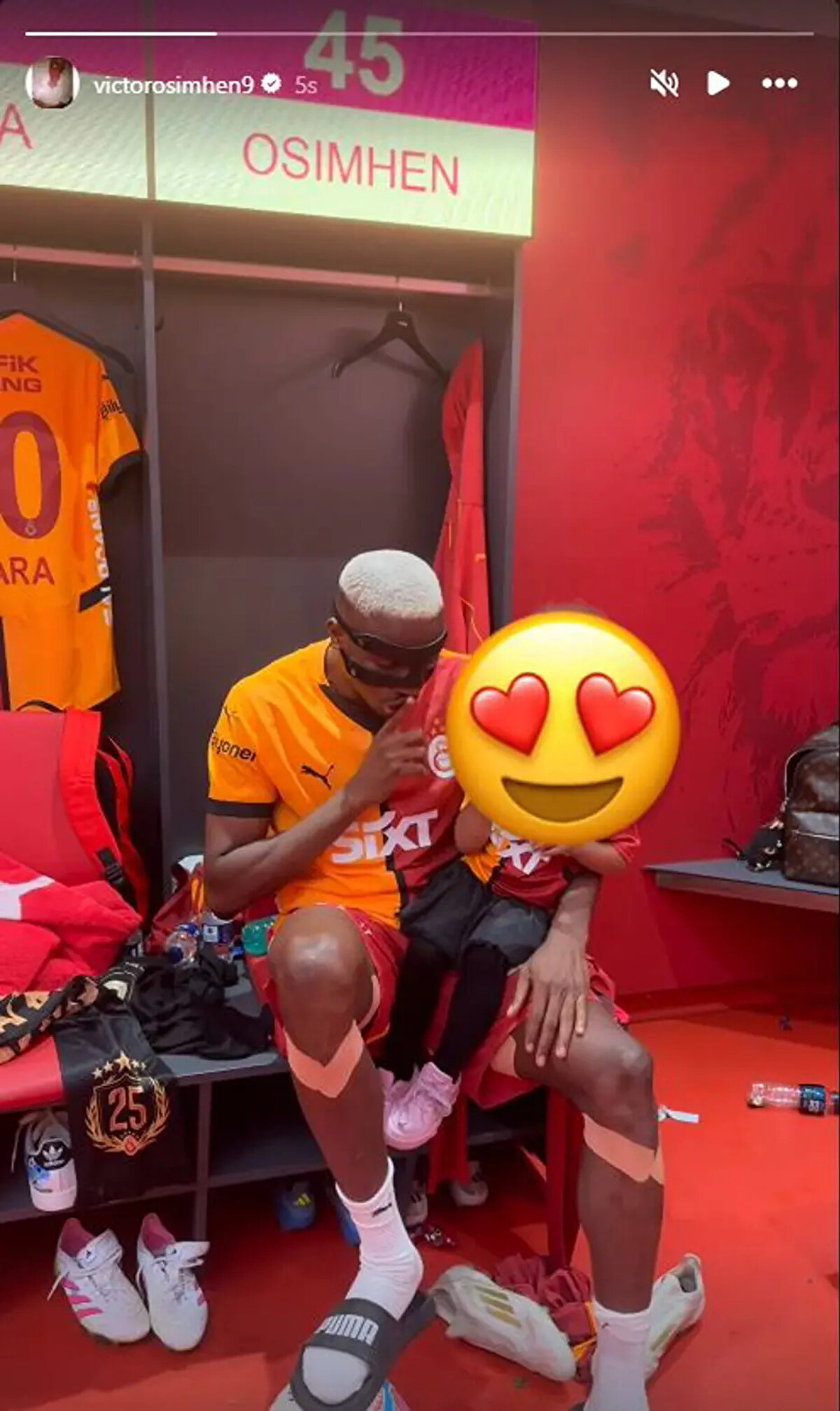 Osimhen, şampiyonluk kutlamaları sonrası 5 yıldızlı Galatasaray formasıyla soyunma odasında kızıyla üçlü çektirdiği anı takipçileriyle paylaştı.<br>