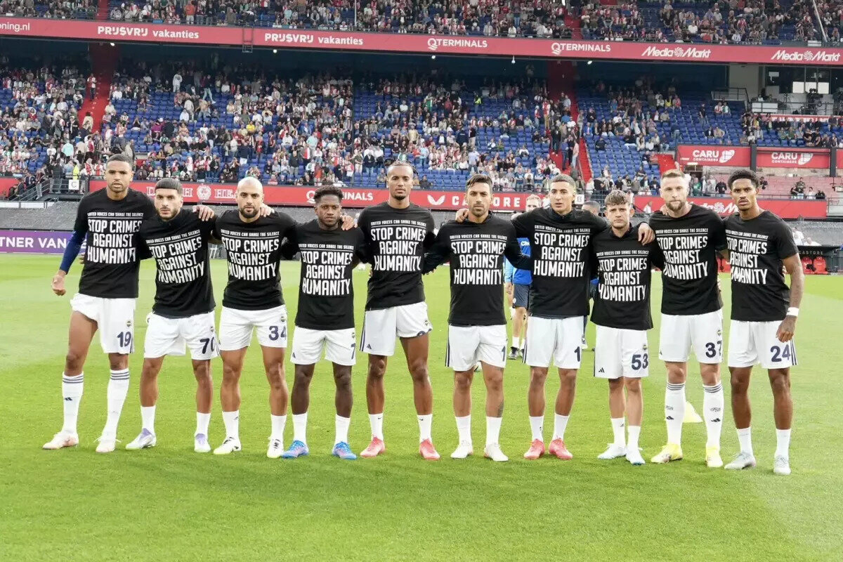 Maç öncesi Fenerbahçe'den anlamlı tepki<br><br>Fenerbahçeli futbolcular, Feyenoord maçı öncesinde ısınmaya Gazze'ye destek tişörtleriyle çıktı.<br> <br>İsrail'in ablukası altında olan Gazze'ye karşı işlenen suçlara tepki gösteren sarı-lacivertliler, üzerinde "İnsanlığa karşı işlenen suçları durdurun" ve "Birleşen sesler sessizliği bozar" yazılı siyah tişörtlerle ısınırken tribünlerden de alkış aldı.<br>Fenerbahçe'de Diego Carlos, Cengiz Ünder, Mert Hakan Yandaş ve Rodrigo Becao listede yer almıyor.