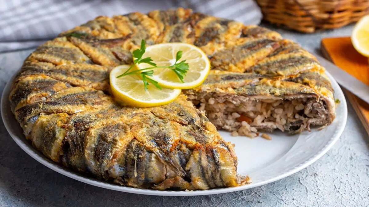 Fırından çıktıktan sonra 10 dakika dinlendirilip dilimlenen hamsili pilav, yanına limon ve taze yeşilliklerle servis edilir.