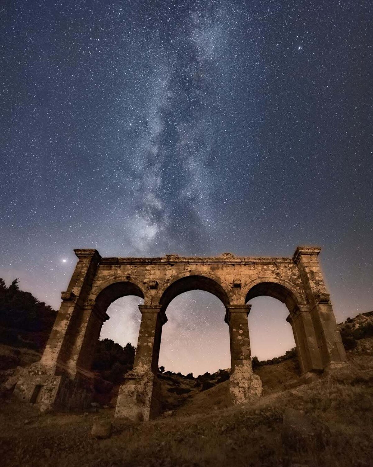 Ariassos’un dikkat çekici planıyla büyüleyen kalıntıları, ziyaretçilerini zamanda bir yolculuğa davet ediyor. Girişte sizi doğudan batıya uzanan bir nekropol alanı karşılıyor. Ardından görkemli şehir kapısı ve kentin kuzey yamacına kurulmuş teraslarla zenginleştirilmiş kent yerleşimi ortaya çıkıyor. 