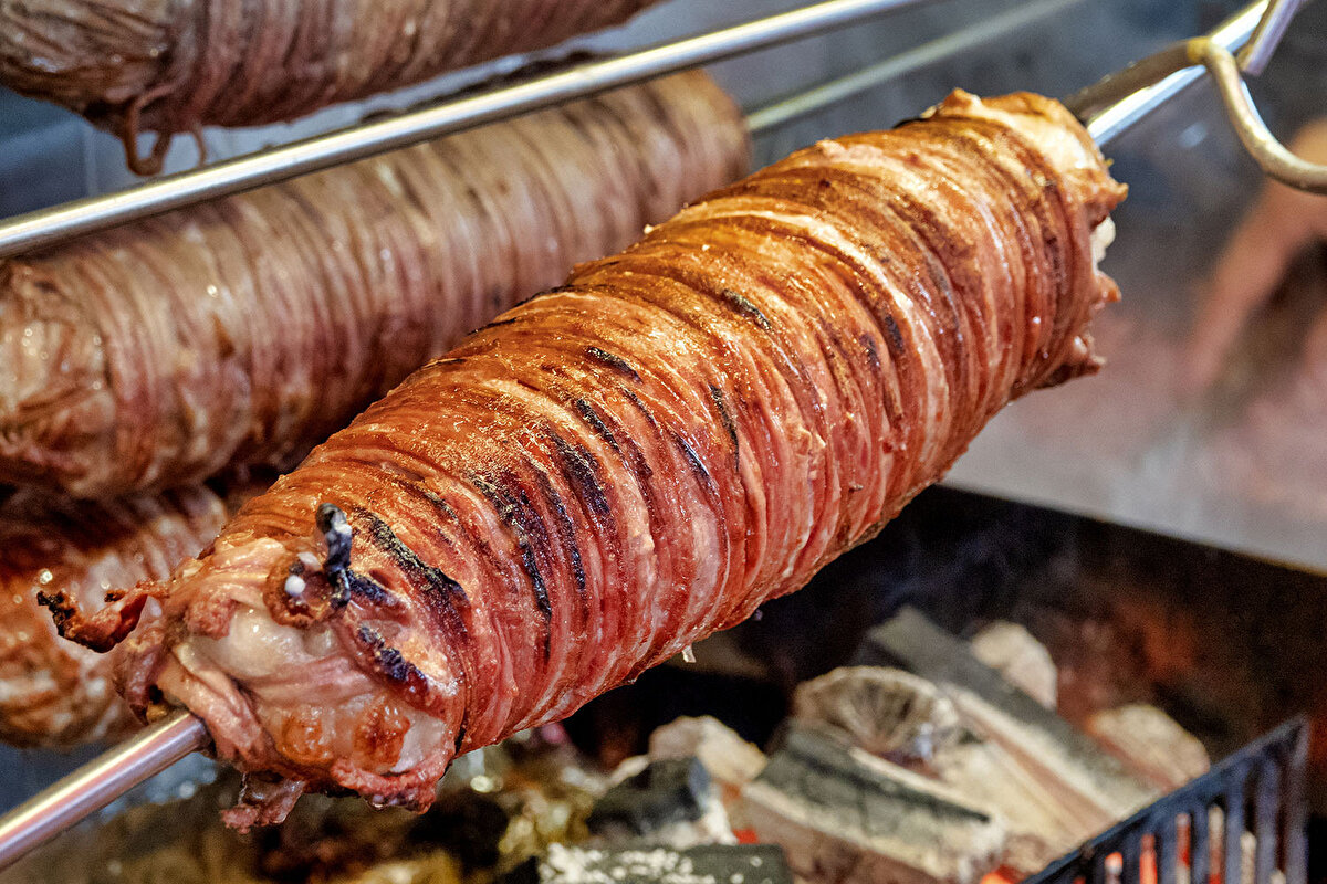 Yapılışı:<br><br>Fırını 180°C’ye ısıtın. Rulo kokoreci ızgaraya yerleştirin, altına yağın akması için bir tepsi koyun. 40–45 dakika pişirin; sürenin yarısında çevirin.<br><br>Fırından aldıktan sonra birkaç dakika dinlendirin.<br><br>Dinlenmiş kokoreci küçük parçalara doğrayın.<br><br>Tavayı ısıtın, zeytinyağını ekleyip kokoreci 3–4 dakika soteleyin.<br><br>Ekmekleri ikiye ayırın, iç yüzeylerini hafifçe tavaya bastırarak ısıtın.<br><br>Ekmeklerin arasına kokoreci yerleştirin, baharatları ekleyin.<br><br>Arzuya göre doğranmış domates ve biberle zenginleştirin.<br><br>Yanında turşu ile servis edin.<br><br>Afiyet olsun!