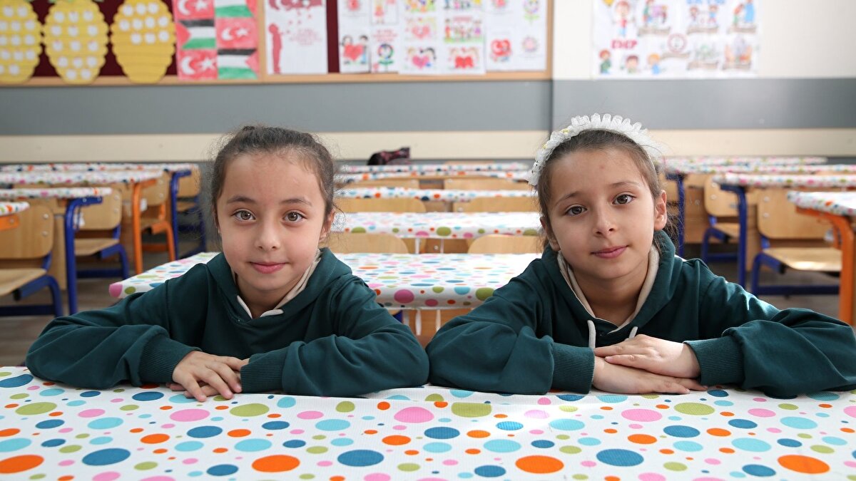 Fiziksel benzerlikleri nedeniyle arkadaşları ve öğretmenlerinin ayırt etmekte zorlandığı ikizler, bu özellikleriyle okula renk katıyor.<br><br>Okulun neşesi haline gelen ikizleri zaman zaman karıştıran öğretmenler, kızlardan farklı toka takmalarını, saçlarını farklı şekillerde örmelerini isteyerek ya da ikizlerin sınıfta yerlerini değiştirerek isimlerini ezberlemeye çalışıyor.