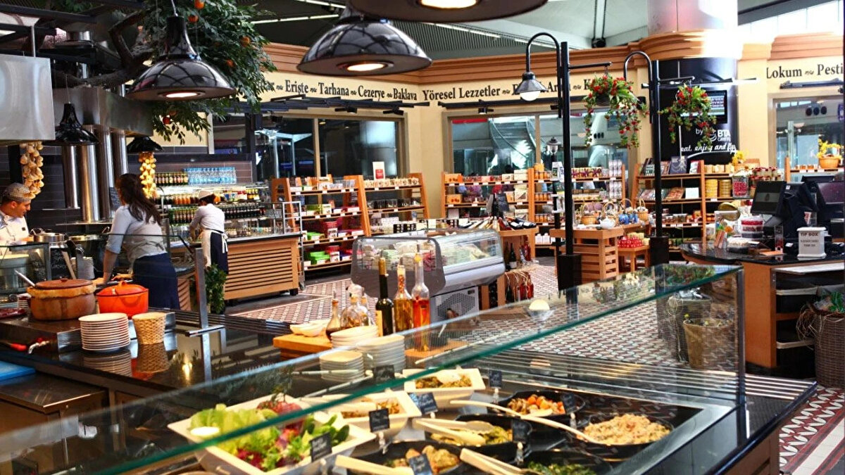 Havalimanlarında satılan yiyecek ve içeceklerin fiyatları, şehir içindeki kafe ve restoranlarla kıyaslandığında çoğu zaman iki katına kadar çıkabiliyor. Peki “Havalimanında yemek fiyatları neden pahalı?” Yolcuların en çok merak ettiği bu sorunun aslında tarihsel, ekonomik ve sektörel pek çok nedeni bulunuyor. Uçak bileti fiyatlarının düşmesinden terminal tasarımlarına, işletme maliyetlerinden tekelci yapıya kadar uzanan bu faktörler, havalimanı fiyatlarının nasıl şekillendiğini gözler önüne seriyor.