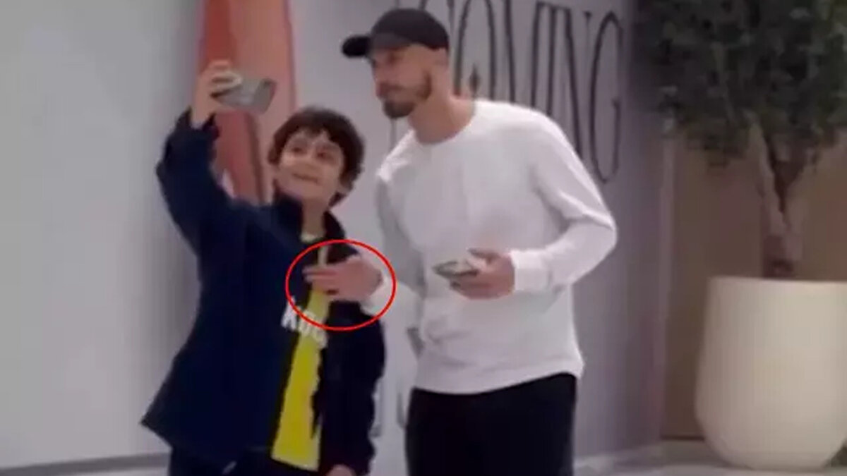 Yıldız futbolcu, fotoğraf çekileceği esnada çocuğun formasındaki Fenerbahçe armasını eliyle kapattı.