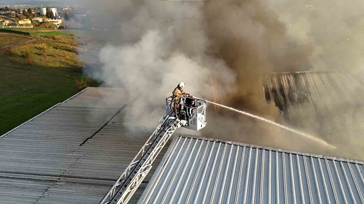 Yoğun duman kilometrelerce uzaktan izlendi<br>Yangının hızla büyümesi üzerine çevredeki işletmeler ve çalışanlar tedirginlik yaşadı. Bölgeden yükselen duman bulutu havadan görüntülenirken, dumanın rüzgârla birlikte İstanbul’un farklı noktalarına doğru sürüklendiği gözlendi. Yangının büyüme riski nedeniyle itfaiye ekipleri çok sayıda araçla bölgeye yönlendirildi.<br><br>Tuzla ve çevre ilçelerden gelen itfaiye birimleri, fabrikanın farklı noktalarına yayılan alevlere eş zamanlı müdahale etti. Yoğun çalışmalar sonucunda yangın kontrol altına alındı. Alevlerin tamamen söndürülmesinin ardından ekipler, tesis içinde yeniden tutuşma ihtimaline karşı soğutma çalışmalarını sürdürüyor.