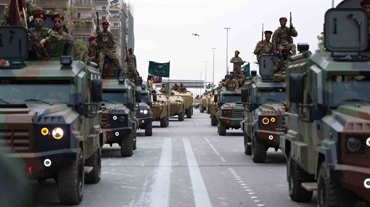 Kutlamalara geniş katılım<br><br>Suriye bayraklarıyla meydanları dolduran halk, tören boyunca sloganlar atarak rejim sonrası yeni dönemin ilk yılını kutladı. Programı, Devlet Başkanı Ahmed eş-Şara’nın yanı sıra Dışişleri Bakanı Esad Hasan Şeybani, kabine üyeleri ve üst düzey komutanlar da takip etti. Geçit töreni, helikopterlerden indirilen birliklerin çevredeki binalara kontrollü inişiyle son buldu.