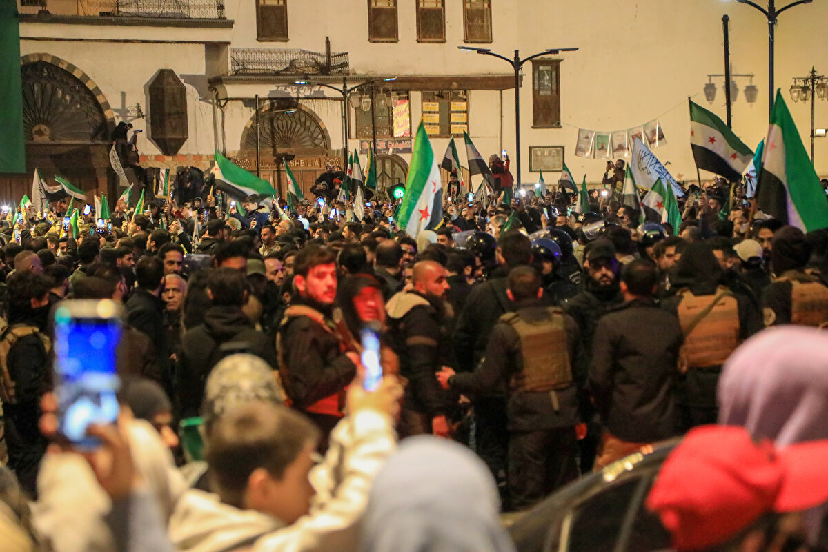 "Özgür Suriye" sloganı atan binlerce kişi, Suriye devrimi ile özdeşleşen çeşitli şarkılar söyleyerek Baas rejiminin devrilmesini kutladı.