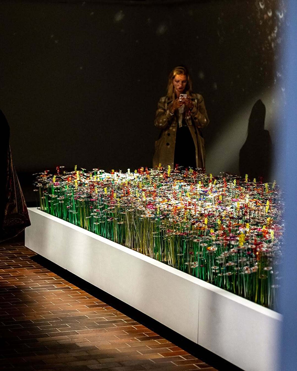 Her bir kutuda 50 çiçek; toplamda 175 kutu… Yani istatistiksel bir toplum kesitini, ışıkla, renklerle ve yansımalarla okunan bir topografyaya dönüştürmüşler. Üstelik tüm çiçekler artık akrilik artıklarından üretilmiş, dijital çağın verisini, üretim kültürünün atık malzemeleriyle harmanlayan sürdürülebilir bir tasarım yaklaşımı.