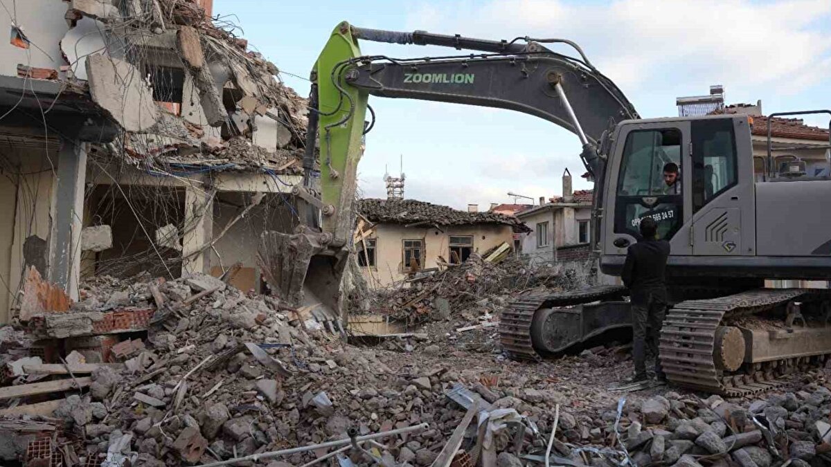 Merkez ve kırsalda eş zamanlı çalışma<br><br>İlçe merkezindeki faaliyetlerle eş zamanlı olarak kırsal mahallelerde de yıkımlar devam ediyor. AFAD ve belediye ekipleri, çalışmalar sırasında çevredeki yapıların zarar görmemesi için önlem alırken, vatandaşların güvenli alanlarda bulunmasına dikkat ediyor.