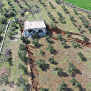 Deprem bölgesindeki bir ev arazide oluşan yarığa gömüldü