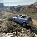 Yoldan çıkan otomobil taşlık alanda asılı kaldı