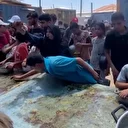 Gazze'de bir çocuk yardım noktasında arda kalanlarla karnını doyurdu