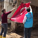 Giresun'da Diyanet görevlileri, çamur içindeki Türk bayrağını yıkayarak temizledi