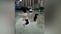 İp atlayan küçük kıza eşlik eden sevimli köpek