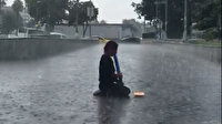 Sağanak yağış altında melodikasını çalmaya devam etti