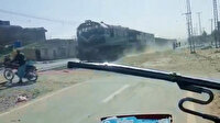 Pakistan'da motosiklet sürücüsü, trenin altında kalmaktan saniyelerle kurtuldu