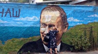 Rusya'da yaşlı kadın Putin'in resmedildiği duvarı öpüyor