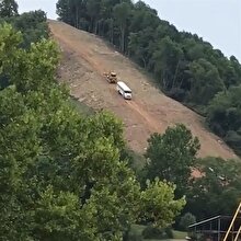 Aşırı dik yokuştan otobüsü indiren iş makinesi