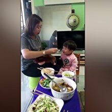 Oyuncak bebek döverek çocuğuna yemek yediren anne kamerada