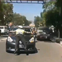Kırmızı ışıkta geçen aracın üzerine atlayarak durduran trafik polisi