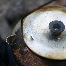 Ormanda kömür ateşinde filtre kahve yapan kampçı