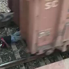 Raylara inen gencin üzerinden yük treni geçti
