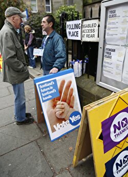 EDINBURGH, SCOTLAND - SEPTEMBER 18: Voters have a conversation in front of a polling station after voting for Scottish independence referendum on September 18, 2014 in Edinburgh, Scotland. Scottish voters continue voting on whether to become independent from Britain in a referendum. (Yunus Kaymaz - Anadolu Agency)