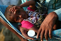 Asma, 2, a Rohingya refugee girl rests in her fathers lap as they arrive at a port after crossing from Myanmar, in Teknaf, Bangladesh.