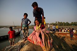 Nurij, 65, an exhausted Rohingya refugee rests after she is carried to a port after crossing from Myanmar, in Teknaf, Bangladesh.