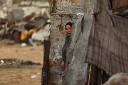 A Palestinian woman gets out of a makeshift house along with a kid on a cold day in Khan Younis district of Gaza City, Gaza on January 05, 2018. Women here collect woods and paper box pieces to burn.
