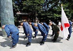 Right wing group members bow their heads to pay tribute to the war dead at Yasukuni Shrine