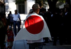 A man wearing Japan's national flag visits Yasukuni Shrine