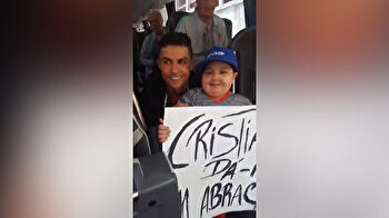 Cristiano Ronaldo hugs young fan holding placard