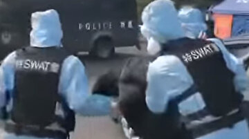 Çin polisi yüksek ateşi çıkan bir sürücüye müdahale ediyor