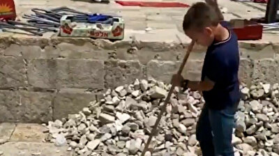 Palestinian kid grabs broom to clean up disaster wrought by Israeli forces in Jerusalem